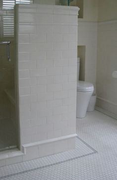 a bathroom with a white tiled shower and toilet