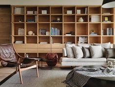 a living room filled with lots of furniture and bookshelves on top of wooden shelves