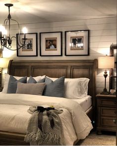 a bedroom with a bed, chandelier and pictures on the wall above it