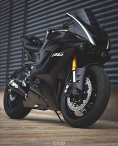 a black motorcycle parked in front of a garage door