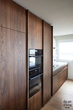 an oven built into the side of a wooden cabinet