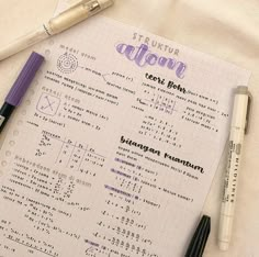 a notebook with some writing on it next to two pens and a calculator