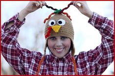 a woman wearing a knitted turkey hat and holding her hands up to her head