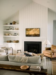 a living room filled with furniture and a fire place under a painting on the wall