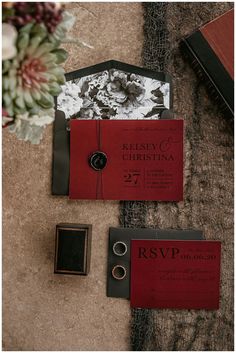 the wedding stationery is laid out on the floor next to an envelope and ring box