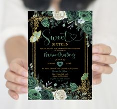 a woman holding up a black and gold sweet sixteen party card with blue flowers on it