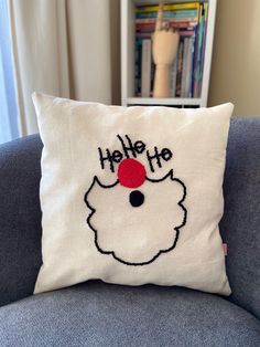 a white pillow with a red santa hat on it that says hello to the front