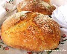 two loaves of bread sitting on top of a floral table cloth next to a loaf of bread