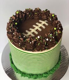 a football cake with chocolate frosting and sprinkles on the top layer