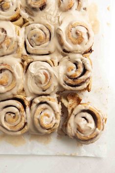 cinnamon rolls with icing on a white surface