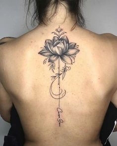 a woman's back with a flower tattoo on it