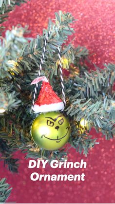 a green ornament hanging from a christmas tree with a red and yellow background