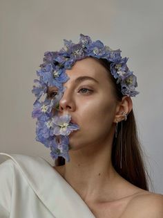 a woman with flowers on her face and one half of her body covered in fabric