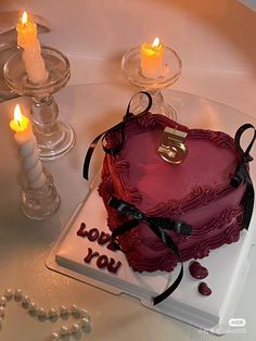 a heart shaped cake on a table with candles