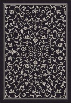 a black and white rug with an ornate design on the bottom, in front of a dark background