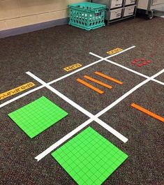 a classroom floor with several pieces of green and orange on it