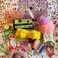 an assortment of items are laid out on a bed with pink and yellow flowers in the background