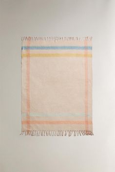 a white wall with a plaid blanket hanging on it