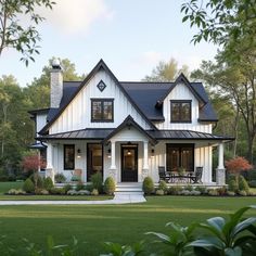 a white house with black roofing and windows in the front yard is surrounded by greenery