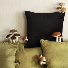 three pillows with mushrooms on them sitting next to each other