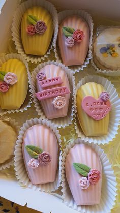 a box filled with lots of pretty decorated cupcakes