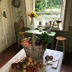 a basket full of vegetables sitting on top of a table in front of a window