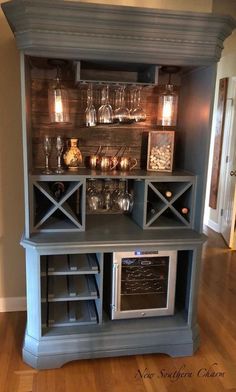 a kitchen hutch with an oven and wine glasses on it's shelves,