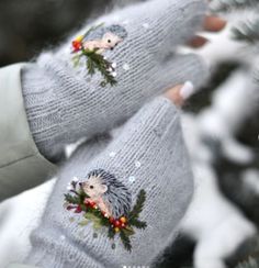 someone wearing grey mittens with hedges on them