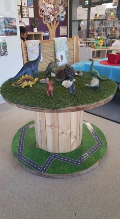 a table with fake dinosaurs on it in the middle of a room filled with children's toys