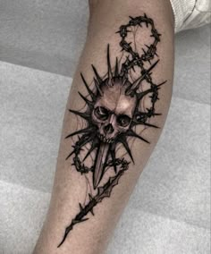 a man's leg with a skull and barbed wire tattoo on the calf area