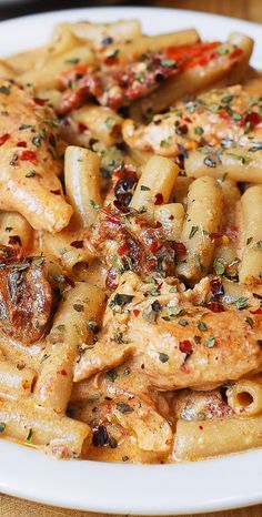 a white plate topped with pasta covered in sauce