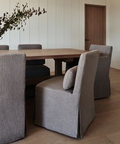 a dining room table with chairs and a plant in the center on top of it