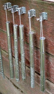 four metal poles are attached to a brick wall