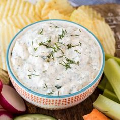 a bowl of dip surrounded by vegetables and chips