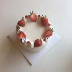 a white cake topped with strawberries on top of a table