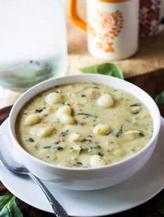 a white bowl filled with soup on top of a plate