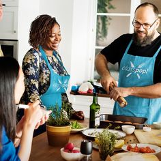 a group of people standing around a table preparing food