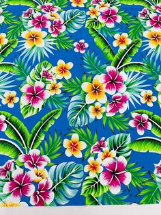 an image of a blue background with flowers and palm leaves on the bottom right corner