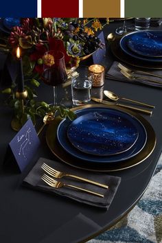 the table is set with blue plates and gold place settings for two people to sit at