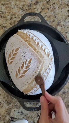 someone is holding a spatula in front of a pan with bread on it and another person's hand near the pan