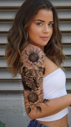 a woman with a sunflower and leopard tattoo on her arm is posing for the camera