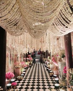 a black and white checkered floor with chandeliers hanging from it's ceiling