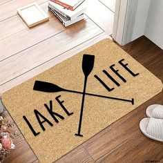 a door mat with the words lake life and two crossed oars