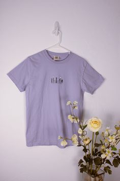 Hand embroidered t-shirt available in both the purple and blue color featured in last picture. T-shirt brand is comfort colors, meaning it is high quality and comfortable. The pattern is eight unique wild flowers/plants and is embroidered with green and white embroidery floss. Items are made to order so please allow 2-4 weeks. Colors Meaning, Embroidered Tee, Purple Shirt, Flowers Plants, White Embroidery, Embroidered Tshirt, The Purple, Embroidery Floss, Shirt Brand