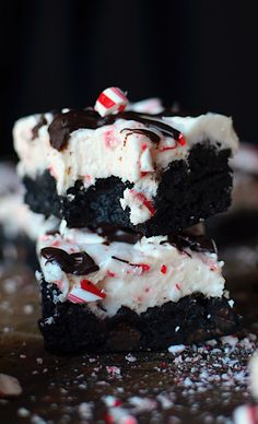 two pieces of cake with white frosting and candy canes on top, stacked together