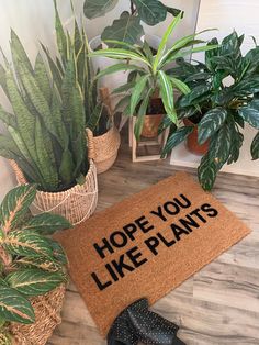 a door mat that says, hope you like plants next to some potted plants