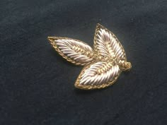 a gold brooch sitting on top of a black cloth