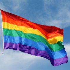 the rainbow flag is flying high in the sky