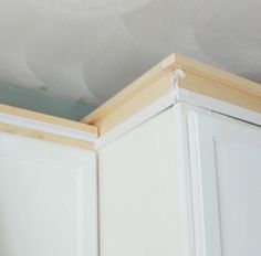 the corner of a kitchen cabinet with white paint on it