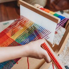 a person is weaving on a loom with their hands